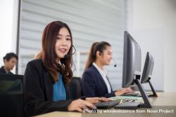Call center with man and woman with headset sitting in office using computer 4d6Rl0