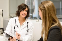 Smiling female doctor with female patient in clinic