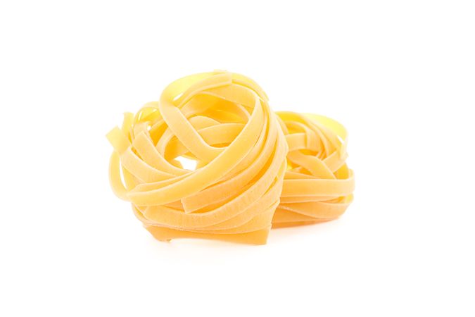 Pasta isolated on light background, closeup. Dry uncooked whole pasta