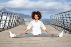 Woman doing side splits on bridge