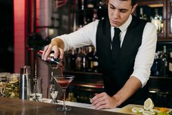 Barman working mixing pouring drink in a glass