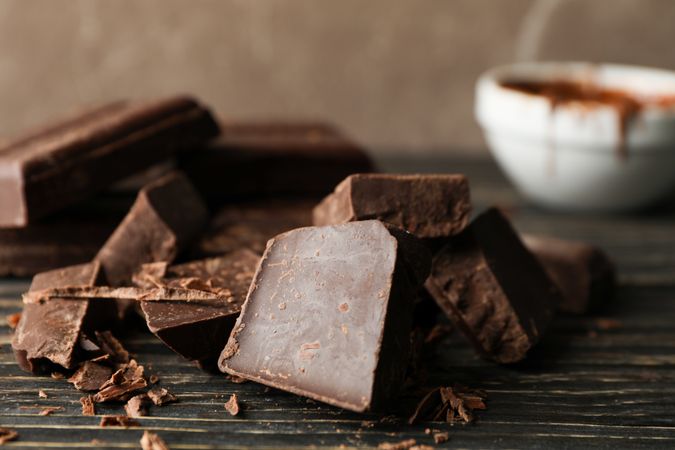 Chocolate pieces on wooden background, close up