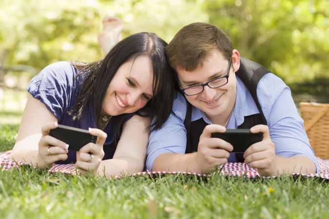 Young Couple at Park Texting Together