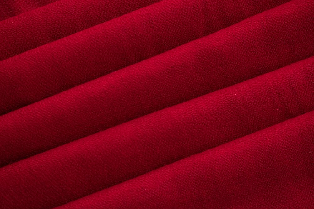 Close up Red folded Fabric Background Texture.