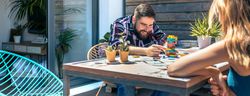Bearded man catching game piece with colleague on terrace