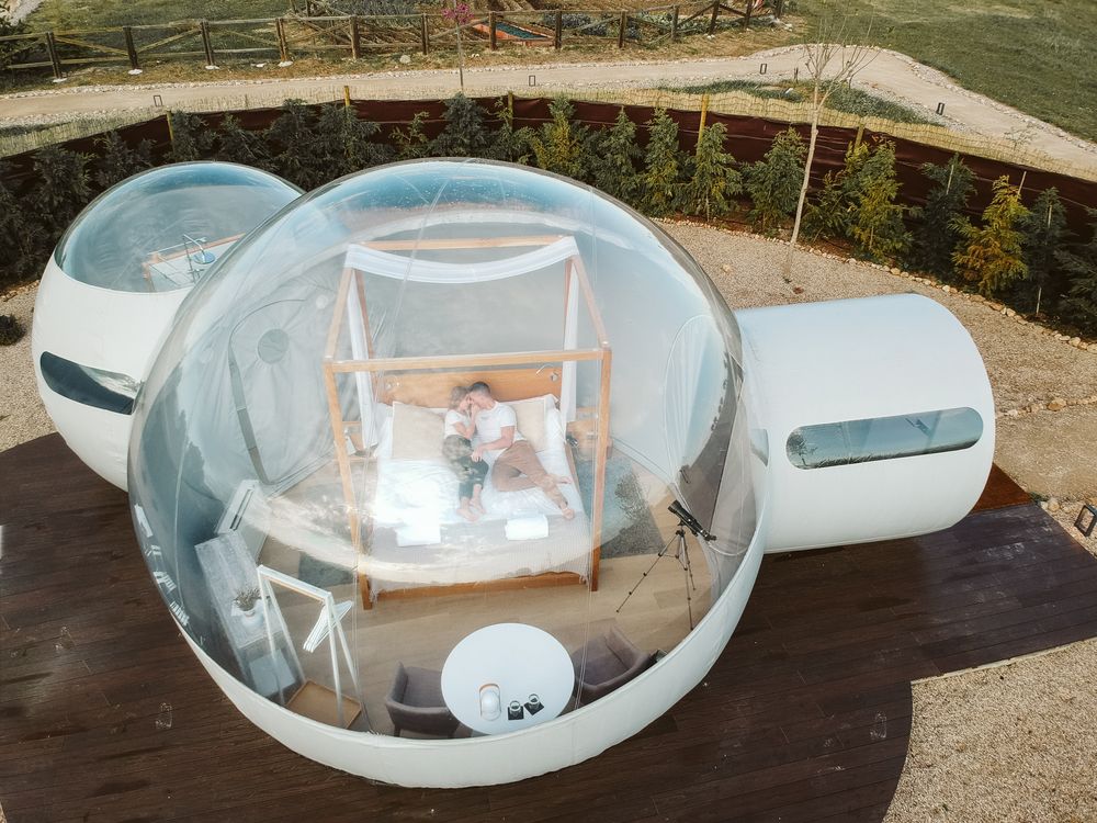 Passionate couple on bed in bubble hotel