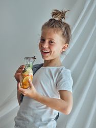 Smiling boy holding glass with metal straw