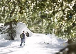 Hiker in snowy forest in Yosemite California