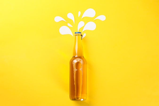 Bottle of beer on yellow background, space for text