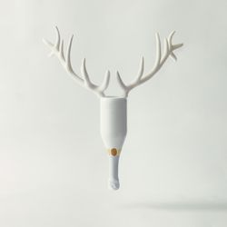 Champagne bottle with reindeer antlers on bright background