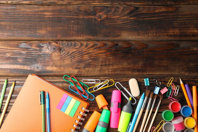 Flat lay composition with school supplies on wooden background, space for text