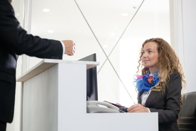 Passenger checking in at airport with female worker
