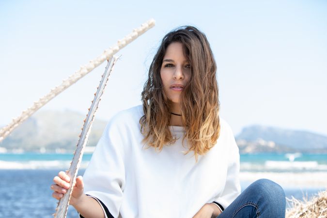 Young woman sitting near dried plants
