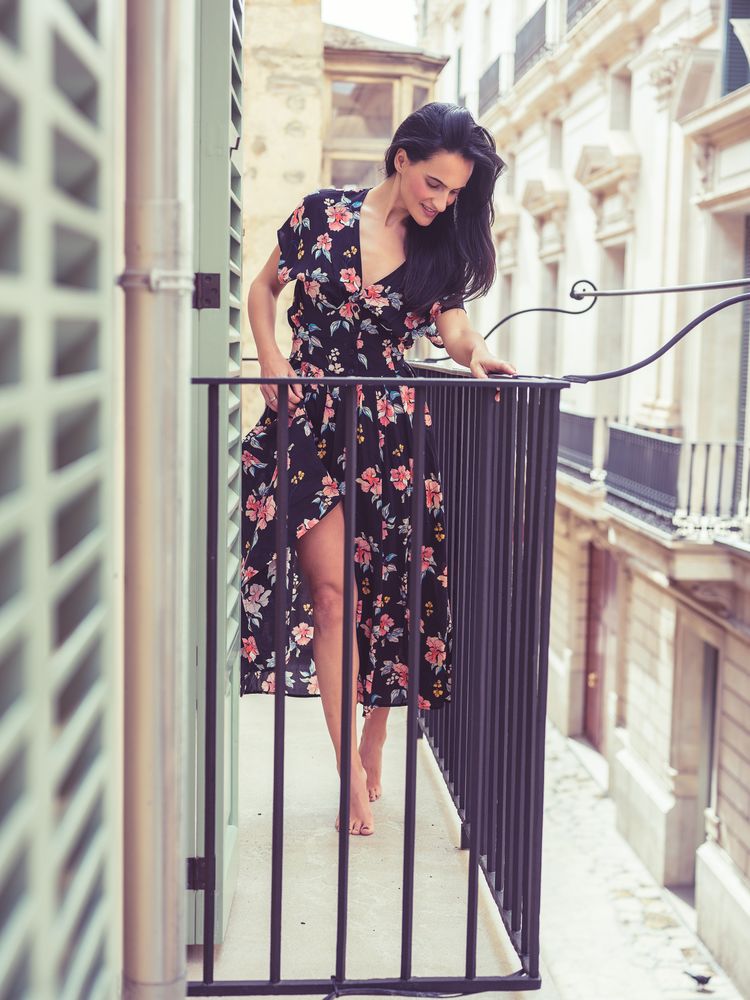Stylish woman in dress on balcony