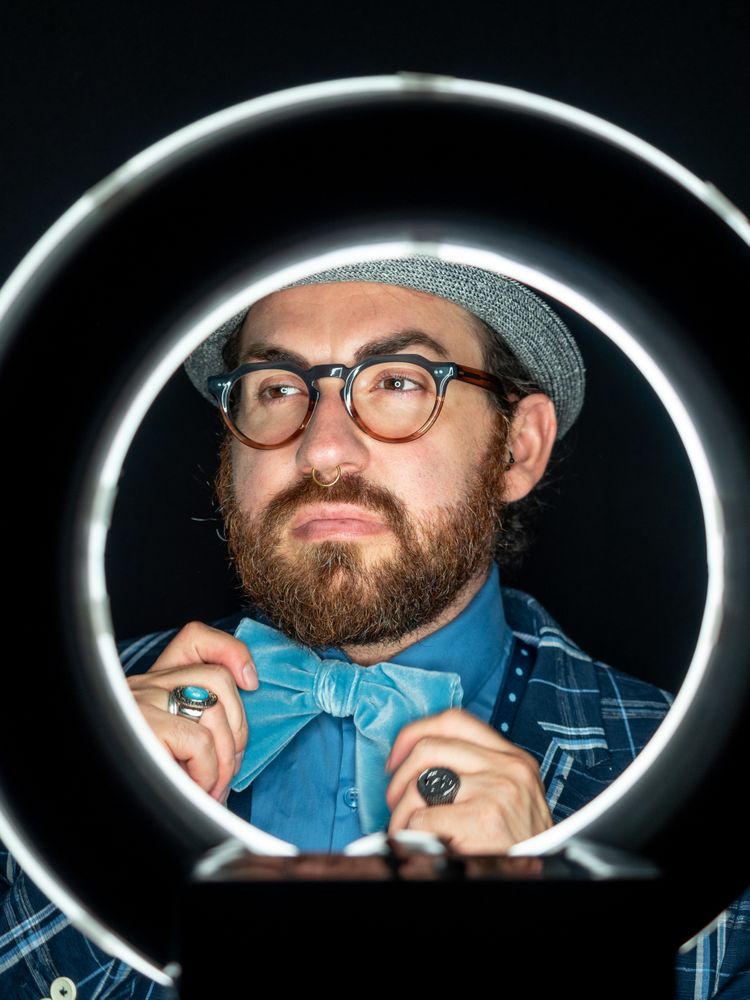 Stylish man in elegant suit behind special circle light