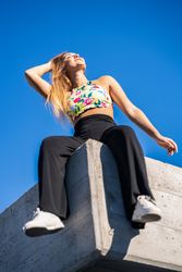 Happy woman sitting on corner of roof