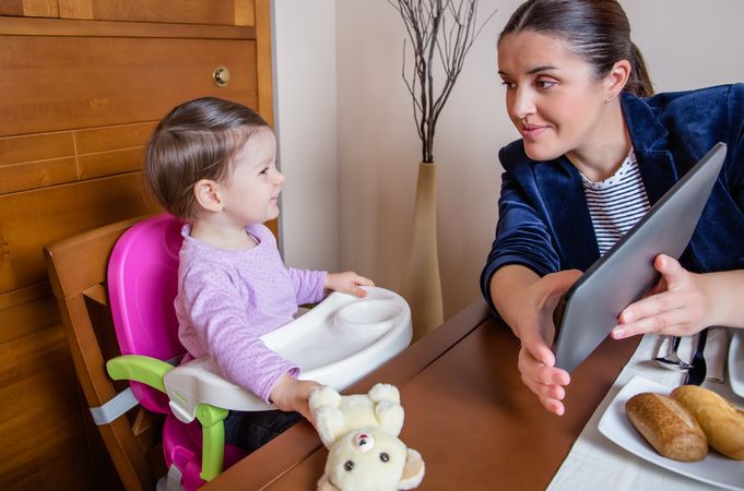 Businesswoman mother and baby girl looking tablet