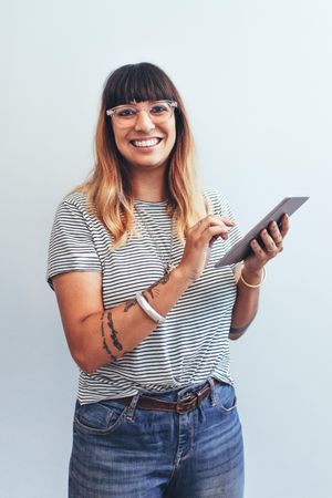 Close up of a smiling businesswoman standing with a tablet pc in hand