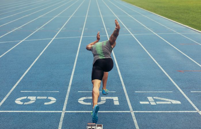 Athlete taking off from starting block on running track