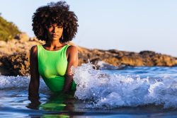 Dreamy Black woman standing in sea during summer vacation