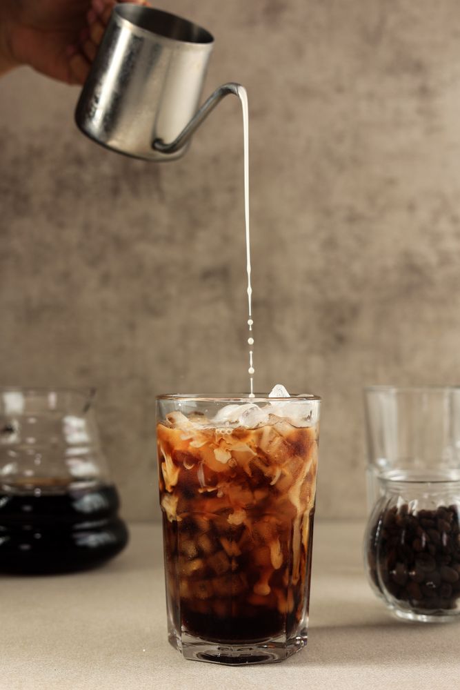 Pour Espresso to the Milk in the Glass Making Iced Coffee Latte