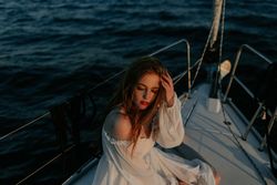 Woman in luxury dress resting on yacht
