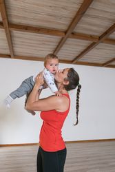 Woman kissing baby in gym