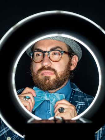 Stylish man in elegant suit behind special circle light