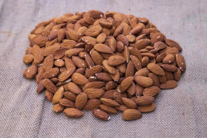 Pile of almonds on brown Jute fiber