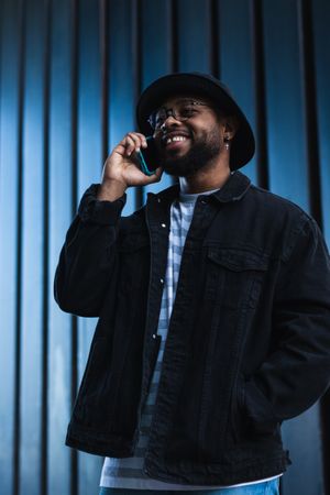Laughing Black man talking smartphone