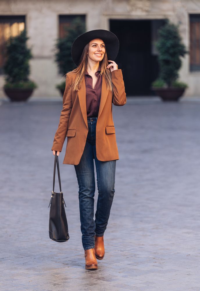 Gorgeous woman in fashionable outfit strolling on city street