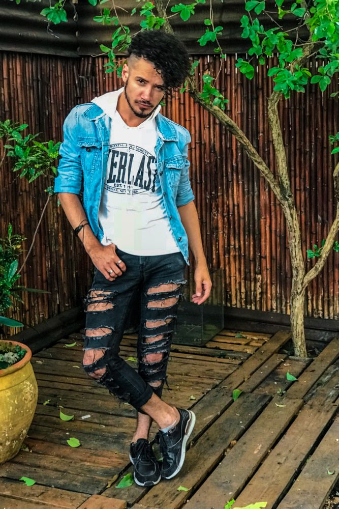 Man in adidas hoodie and dark pants standing outdoor