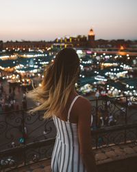 Stylish woman against oriental glowing city in night