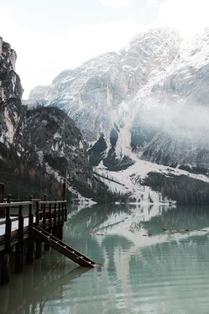 Wooden pier on stilts on lake near mountains