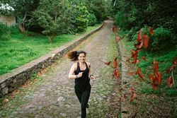 Positive woman running in park