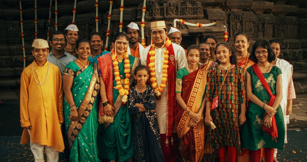 Portrait of Happy Indian Family Looking at the Camera, Holding a Statue of their Deity.