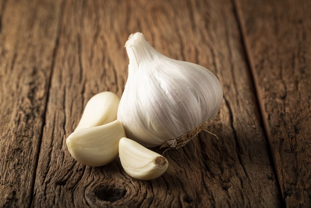 Garlic bulb and garlic cloves on the wooden table.