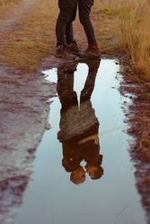 Men hugging and kissing near water puddle
