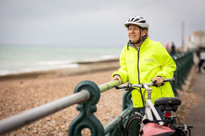 Calm older woman enjoying coastal view from bike