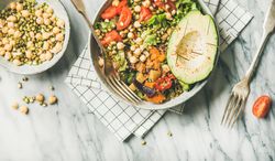 Healthy vegan lunch bowl with avocado, grains, vegetables, horizontal composition, with copy space