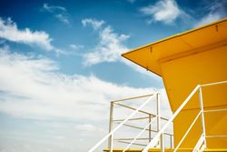 Upshot of yellow lifeguard station and a blue sky