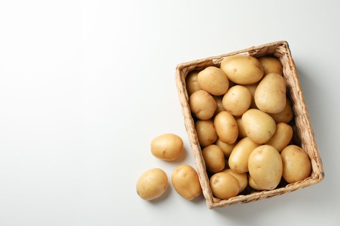 Top view of wooden box full of potatoes, copy space