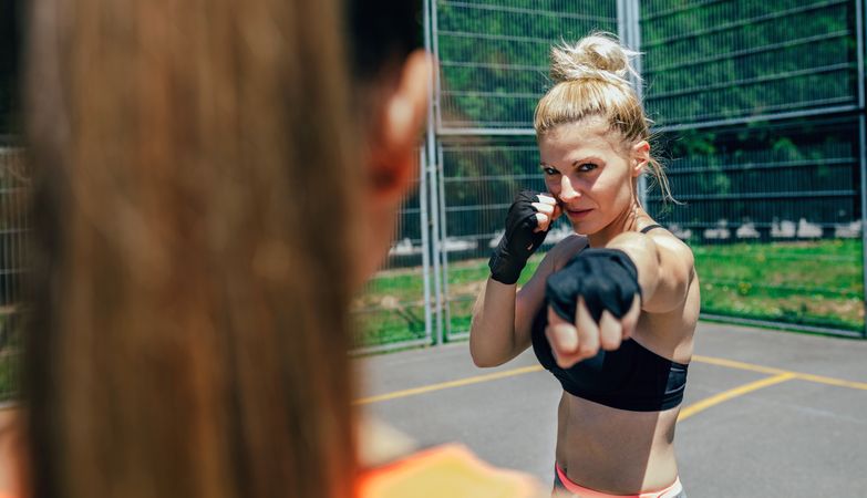 Sportswoman training boxing with her trainer