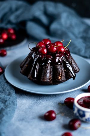 Chocolate cherry cake on table with scattered cherries