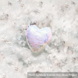 Heart in iridescent sequins on snowy background 5QWOgb