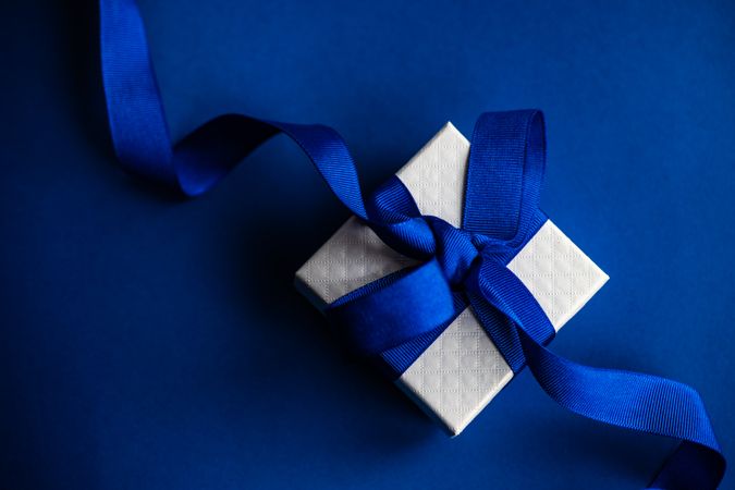 Valentine present with blue ribbon on blue table