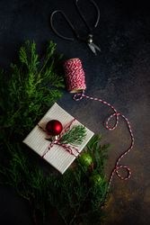 Top view of single Christmas gift with red bauble and fir