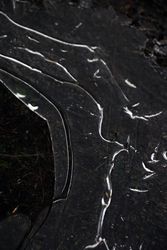 Fragment of thin ice on dark frozen river