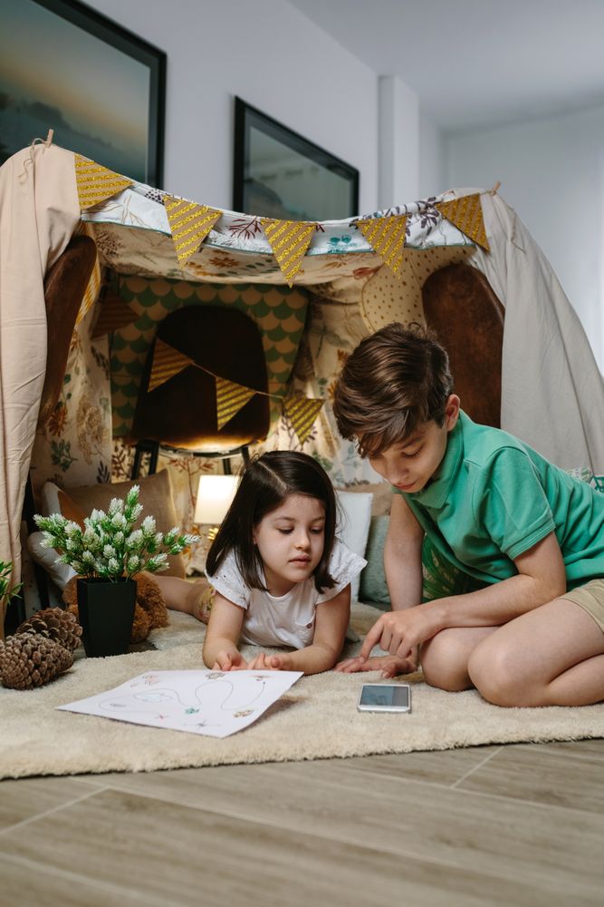 Brothers playing in a diy tent in the living room