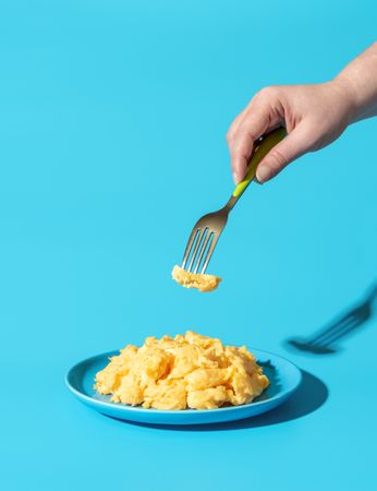 Eating scrambled eggs, minimalist on a blue background